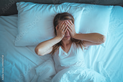 Tablou pe pânză Young stressed woman lying on bed late at night suffering from insomnia, sleep apnea or stress
