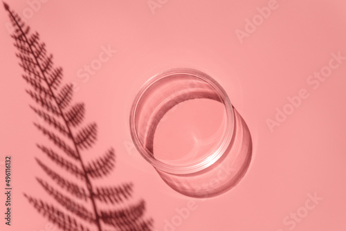 Empty laboratory glass petri for serum, oil, beauty products on pink background. Natural medicine, cosmetic research, bio science. Concept of skincare and analysis. Dermatology. Flat lay, top view