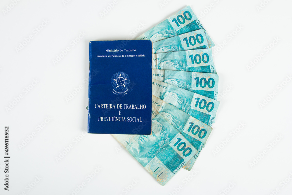 Brazilian document work and social security (Carteira de Trabalho e Previdencia Social) with Brazilian money banknotes Brazilian document work and social security (Carteira de Trabalho e Previdencia Social) with Brazilian money banknotes
