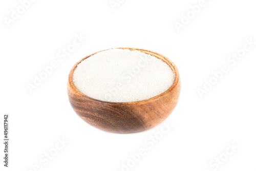 Wooden bowl with white sugar on a white background.
