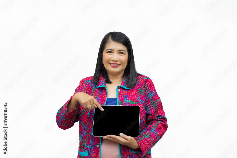 Portrait confident middle-aged Asian woman wearing pink casual wear pointing a finger to a tablet isolated on white background Portrait confident middle-aged Asian woman wearing pink casual wear pointing a finger to a tablet isolated on white background
