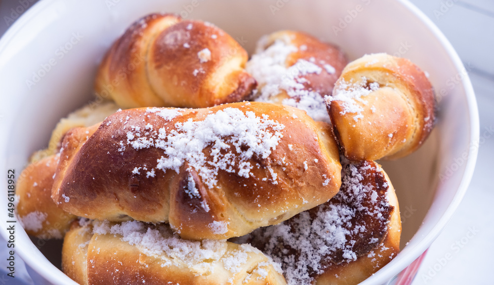 sweet buns with powdered sugar plate close-up
