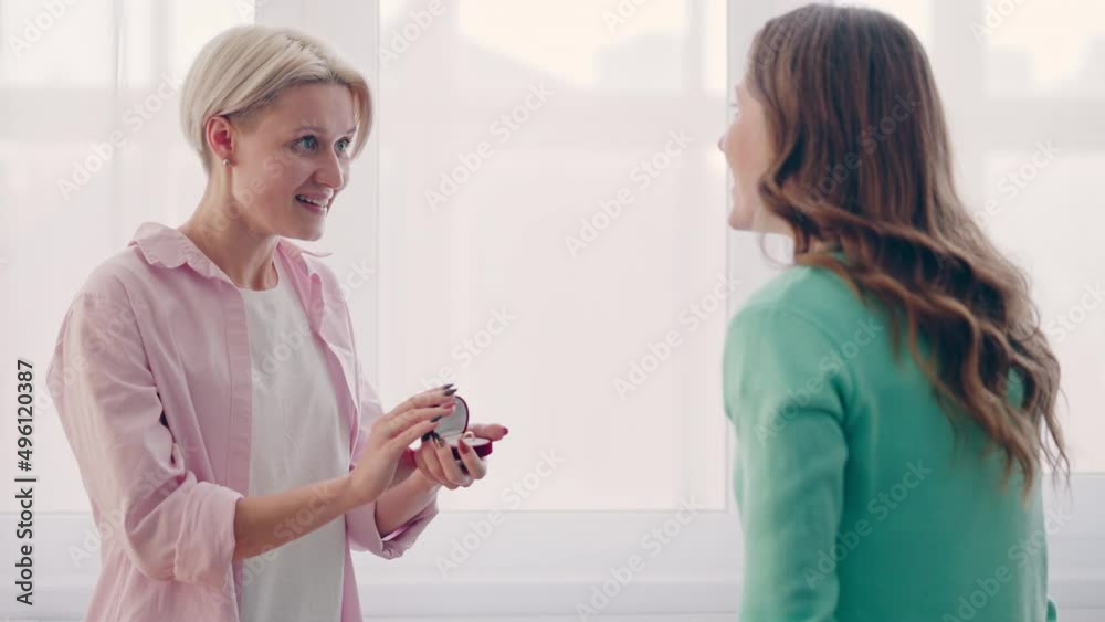Blond lesbian woman making proposal to her girlfriend, showing engagement ring Blond lesbian woman making proposal to her girlfriend, showing engagement ring
