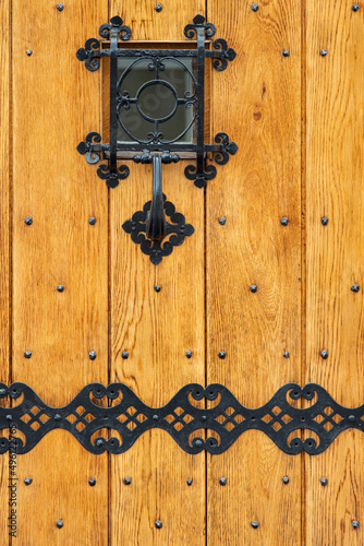 Wooden entrance door with wrought iron elements.