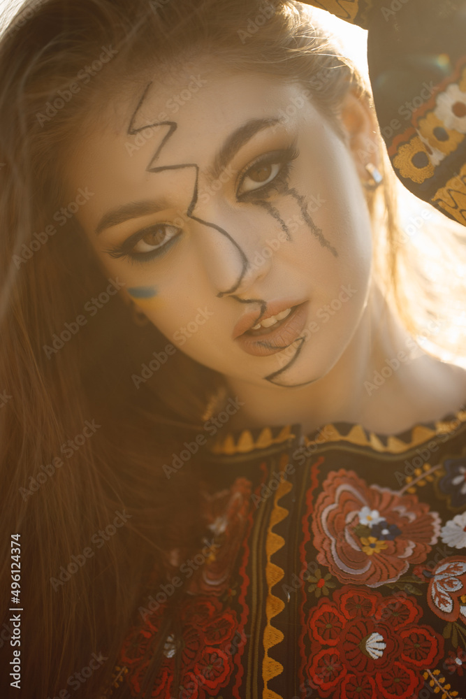 Fototapeta premium Close-up of a Ukrainian girl with tears in her eyes, wearing national clothes, a sad expression.