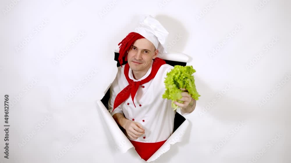 A handsome man with red dreadlocks holds it in his hand milk. Confident young cook in white apron and red tie holding a bottle of milk, peeking through ripped white paper background in studio A handsome man with red dreadlocks holds it in his hand milk. Confident young cook in white apron and red tie holding a bottle of milk, peeking through ripped white paper background in studio