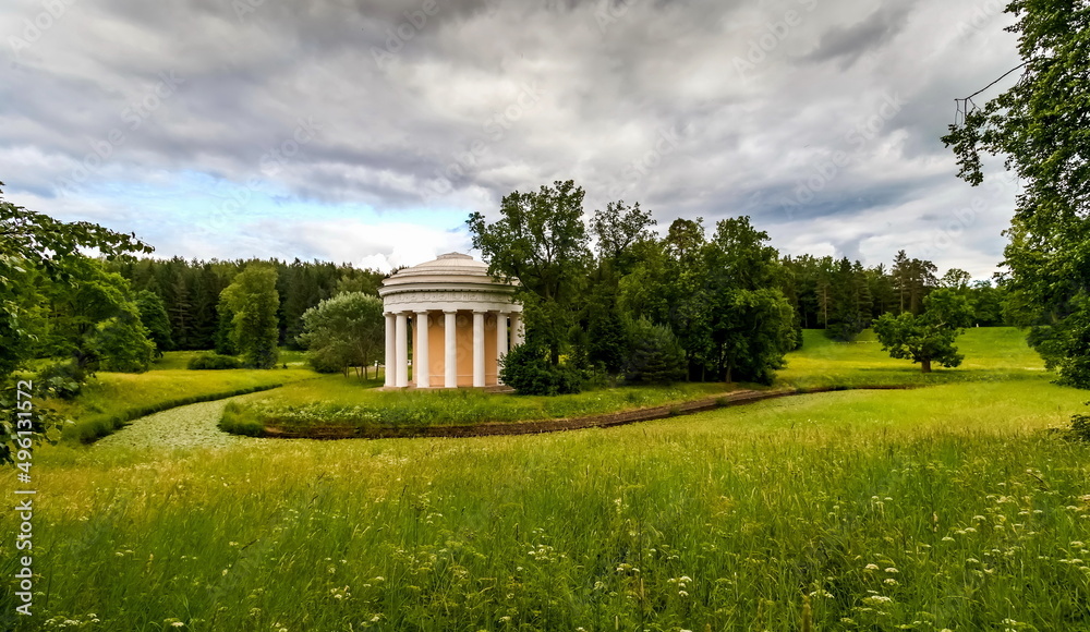 Summer landscape in a city Park with trees, pavilion, river, sky with clouds