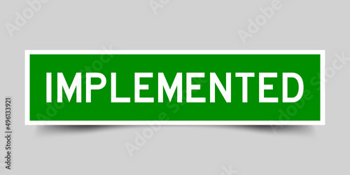 Sticker label with word implemented  in green color on gray background
