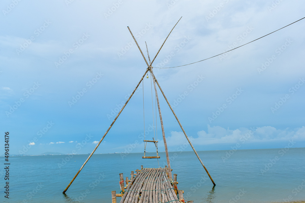 lonely empty bamboo swing in the sea beautiful blue sky background