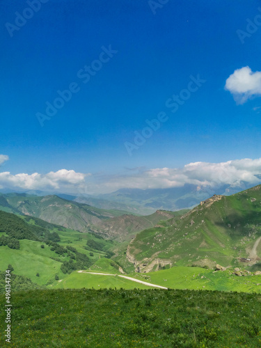 The landscape of the green Aktoprak pass in the Caucasus, the road and the mountains under gray clouds. Russia.