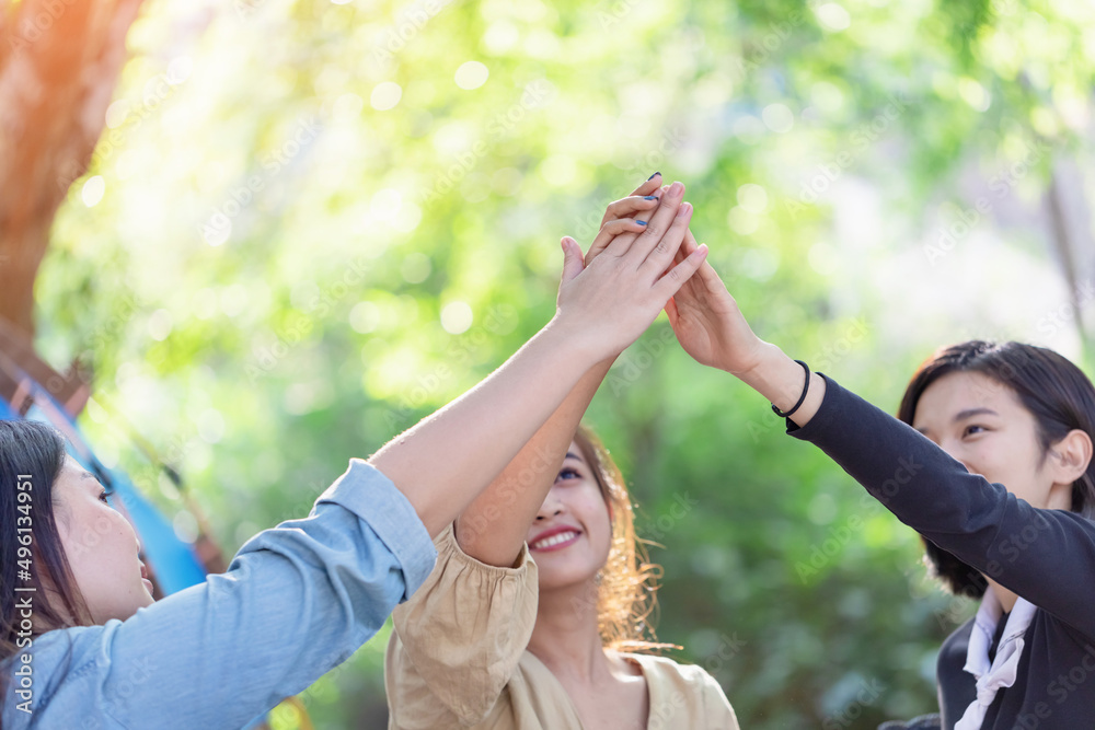 Obraz premium Group girls hands together giving high five feels excited close up focus on stacked palms. celebration and friendship concept