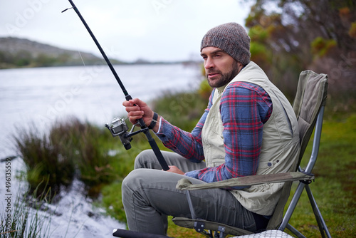 Hes got a whole weekend of fishing ahead of him. Shot of a handsome man fishing at a natural lake.