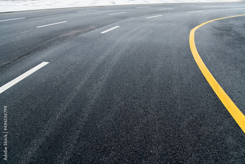 Asphalt road with white stripes and yellow lines