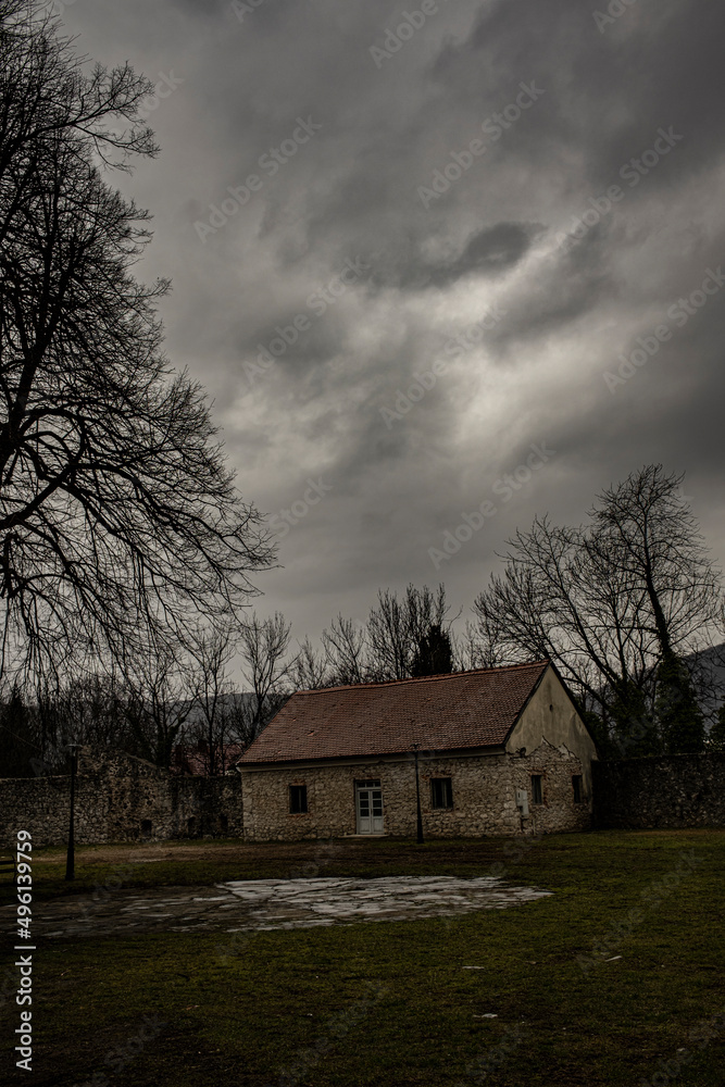 ground floor stone building in solitude, early spring, cloudy skies ground floor stone building in solitude, early spring, cloudy skies