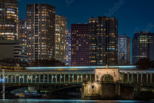 Famous Bir Hakeim Bridge Enlightened at Night in Paris With Builings and Hotels Behind photo