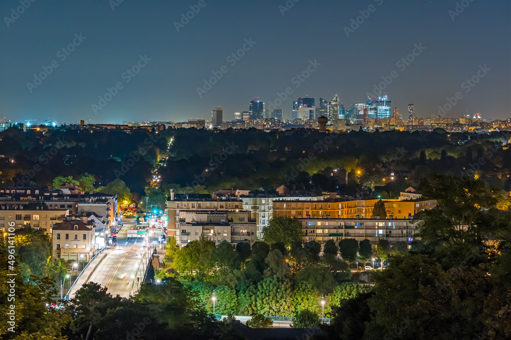 Night Traffic in Paris Suburbs with La Defense in Background Forest and Buildings