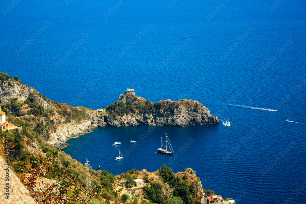 Ships docked in the cove surrounded by rocky cliffs. Amalfi coast, Italy.