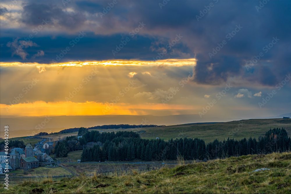 Fototapeta premium Intense Yellow Light at Sunset Through the Clouds in French Lowland Mountains