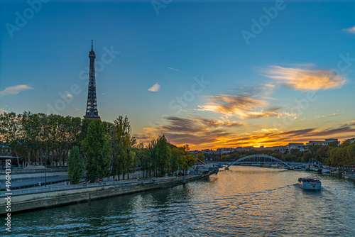 Tourists on Boat Cruise at Golden Hour in Paris With Orange Sky and Eiffel Tower