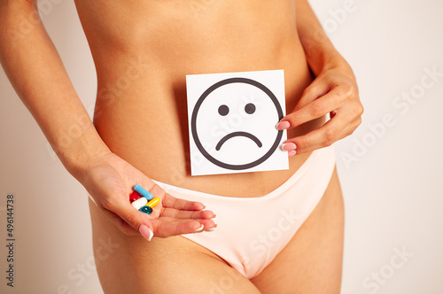 Woman Health, Female Body Holding Sad Smile Card Near Stomach. © Maksymiv Iurii