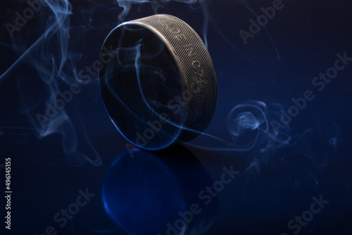 Closeup of a black ice hockey puck againsta blue background. photo