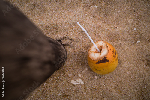 Unawatuna, Sri Lanka A coconut with a straw is discarded on the beach. photo