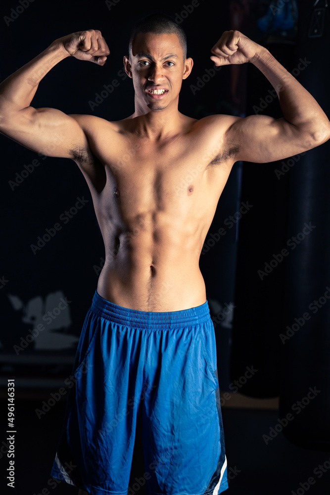 Strong Hispanic athlete showing muscles Strong Hispanic athlete showing muscles