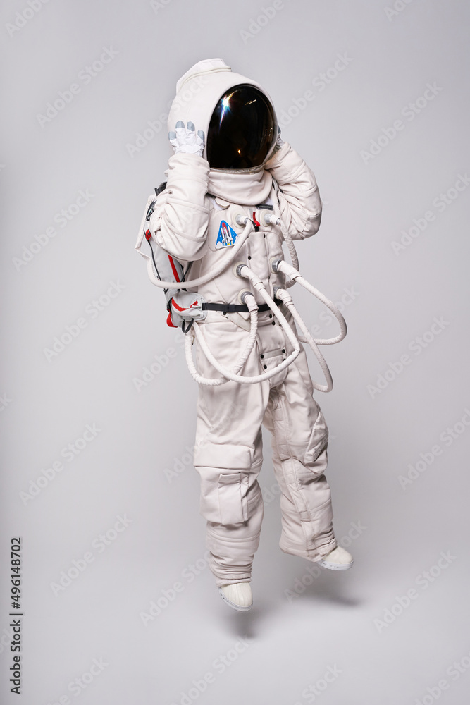Anonymous astronaut in spacesuit and helmet in studio Anonymous astronaut in spacesuit and helmet in studio