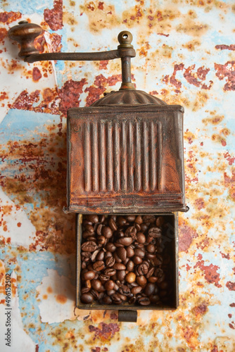 stary młynek do kawy i ziarna kawy na kolorowym tle 