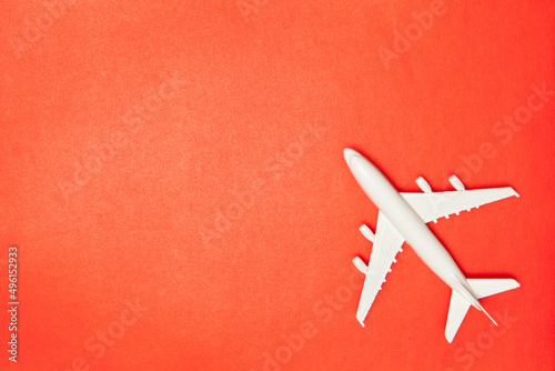 Airplane model. White plane on red background. Travel vacation concept. Summer background. Flat lay.