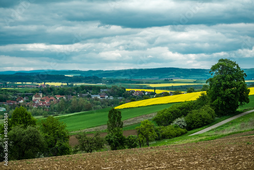 Bayern, Unterfranken, Grabfeld, Frankenschwelle, klassische mitteldeutsche Landschaft mit Dörfern und blühenden Rapsfeldern bei Höchheim photo