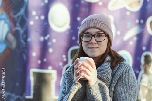 Cute girl with glasses with a cup of coffee in the park © Сергей Стельченко