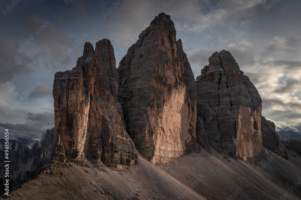 Fototapeta premium Three Peaks mountain summits in the Dolomite Alps in South Tyrol with clouds during sunset.
