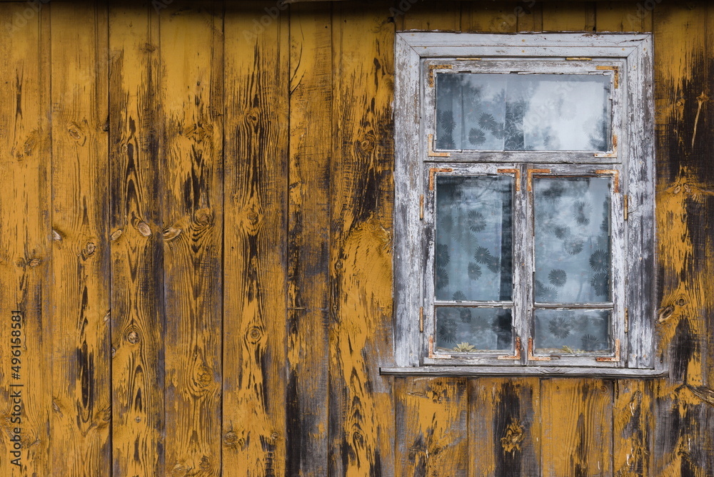 Naklejka premium Rustic window in wooden village cottage house. Yellow wood wall