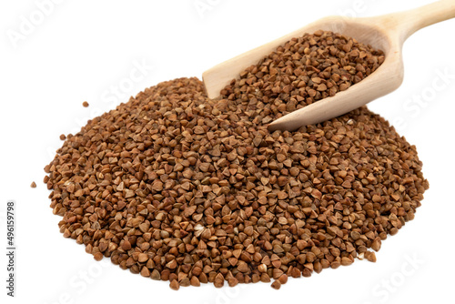 A bunch of buckwheat with a wooden scoop on a white background. Natural healthy food, vegan diet. Buckwheat groats closeup isolate