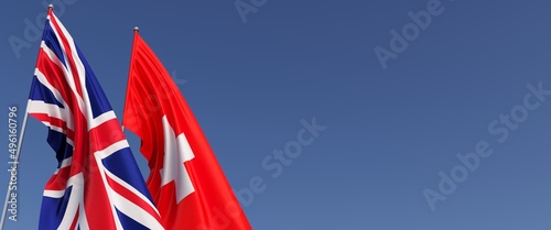 Flags of the United Kingdom and Switzerland on flagpoles on side. Flags on a blue background. Great Britain, England. Geneva. 3D illustration.