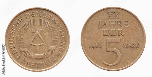 Germany East GDR - circa 1969 : a five German Mark coin of the GDR with the Hammer and circle coat of arms of the GDR and oak leaves on the number 5 photo