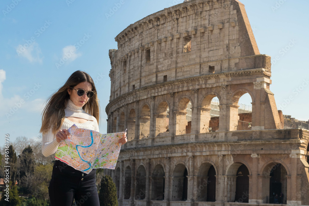 Young tourist woman in Rome with map and the Roman coliseum in the background