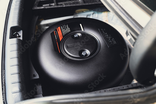 Car donut-shaped LPG tank in a spare wheel hole on the car trunk photo