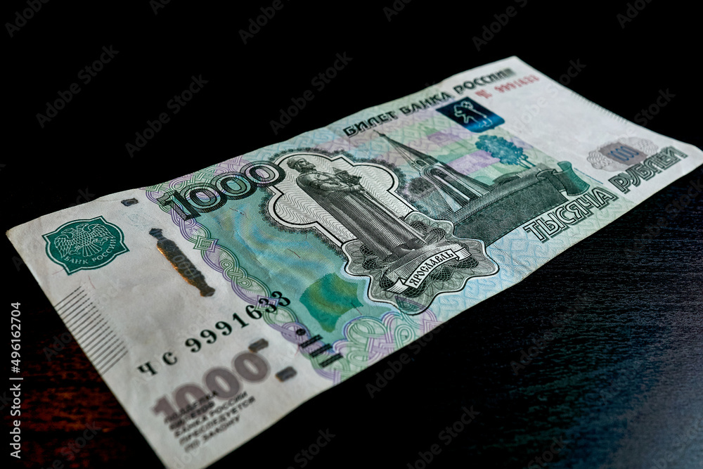 A bill of one thousand rubles on a dark table A bill of one thousand rubles on a dark table