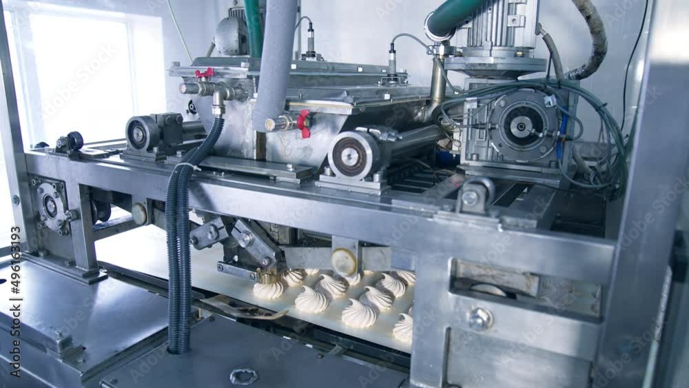 Automatic machine with complicated mechanism working and producing marshmallows. Equipment at modern food factory. Automatic machine with complicated mechanism working and producing marshmallows. Equipment at modern food factory.