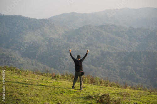 solo backpacker man happy and joyful after success climb the mountain