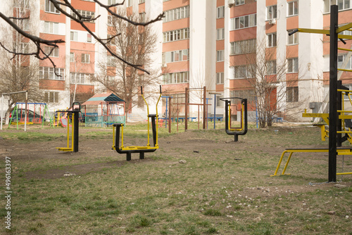 Outdoor gym in the courtyard of apartment buildings. Outdoor fitness equipment in the public yard. Sports simulators in the park © natalyamatveeva