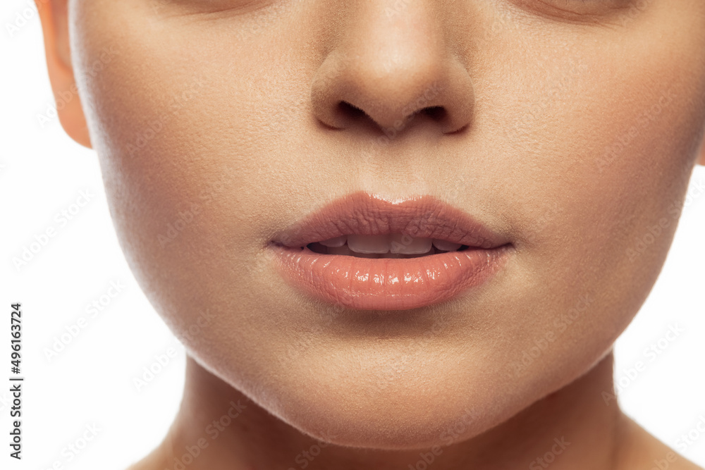 Obraz premium Cropped close-up image of female lips, cheecks and nose isolated over white studio bacground