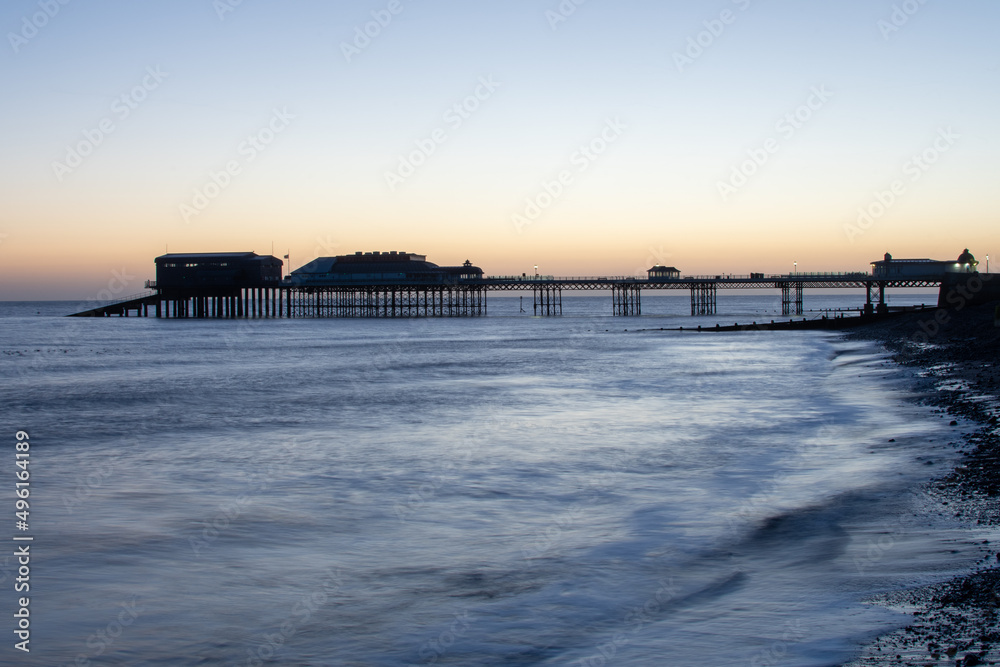 Sunrise over the beach, pier and promenade at Cromer in north Norfolk, UK