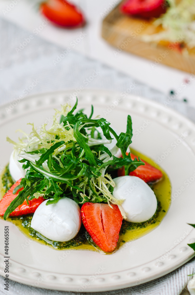Light summer fresh salad. Buffalo mozzarella with strawberries, pesto, arugula and lettuce. Light summer fresh salad. Buffalo mozzarella with strawberries, pesto, arugula and lettuce.