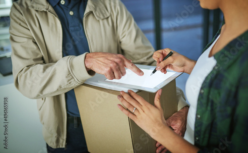 An electronic signature releases her package. Cropped shot of a woman using a digital tablet to sign for a package from a delivery man.