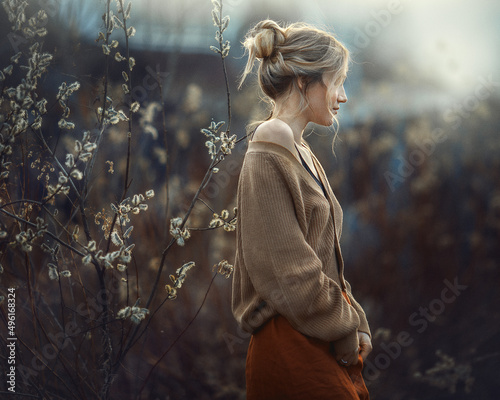 a girl in early spring in a flowering willow, photos with noise effect and selective focus