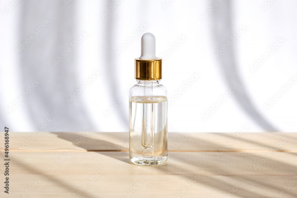 Natural oil cosmetics. Dropper glass Bottle Mock-Up. Oily cosmetic pipette. Face and body treatment. Spa concept. Mineral organic liquid. Front view. Beauty products. Blank packaging on wooden table Natural oil cosmetics. Dropper glass Bottle Mock-Up. Oily cosmetic pipette. Face and body treatment. Spa concept. Mineral organic liquid. Front view. Beauty products. Blank packaging on wooden table