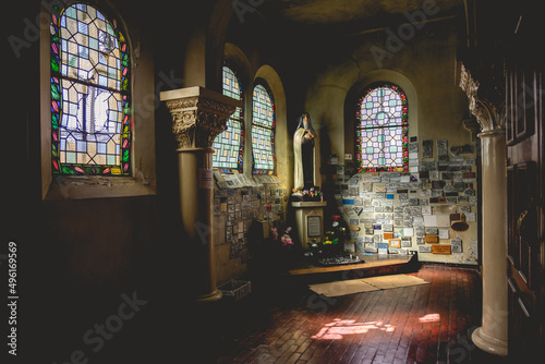 Photography Interior with colorful stained glass windows, columns and altar with holy woman